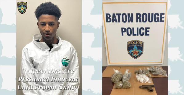 A 19-year-old clean shaven black male with curly dark hair wearing a zippered white overall top. There is also a table with what appears to be marijuana and a white powdery substance in plastic bags, as well as a firearm. The words "Baton Rouge Police" are in the background.