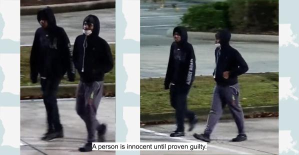 Two black males. Both are wearing black hoodies and walking in a parking lot.