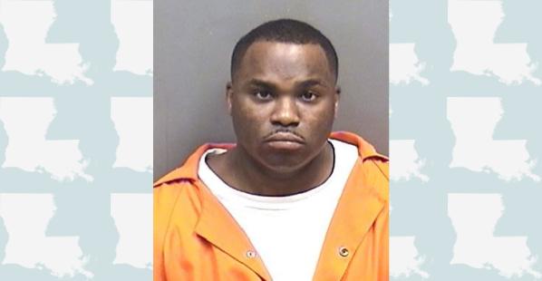 A black male with short dark hair. He is wearing and orange correctional center shirt with a white undershirt.